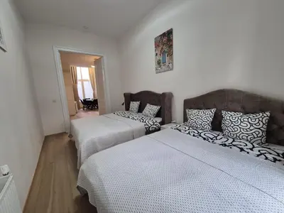 two beds in a room with white walls at Tasson Snel apartment center of Brussels in Brussels