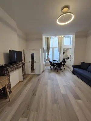 a living room with a blue couch and a table at Tasson Snel apartment center of Brussels in Brussels