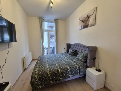 a bedroom with a bed and a tv and a window at Elegant apartment in center of Brussels in Brussels