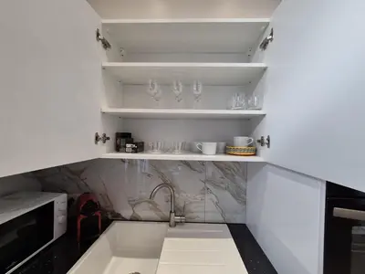 a kitchen with a sink and shelves with glasses at Elegant apartment in center of Brussels in Brussels