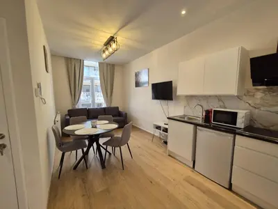 a kitchen and living room with a table and chairs at Modern apartment near Avenue Louise in Brussels