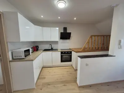 a small kitchen with white cabinets and a microwave at Cosy duplex in center of Brussels in Brussels