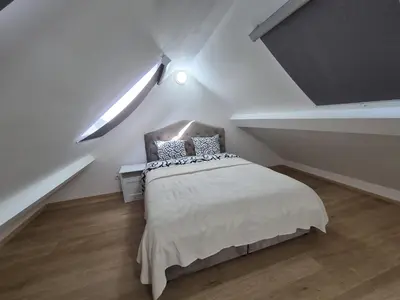 a white bedroom with a bed in a attic at Cosy duplex in center of Brussels in Brussels