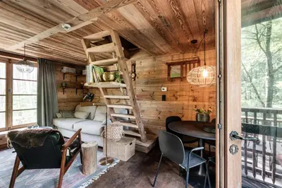 a tiny house with a loft bed and a desk at Tjiftjaf in Retie