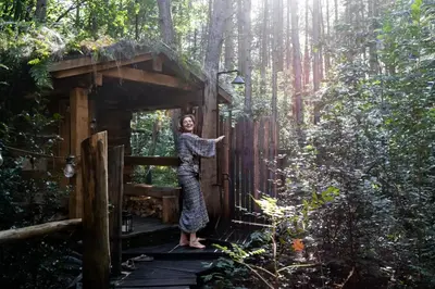 a woman standing inside of a tree house in the woods at Tjiftjaf in Retie