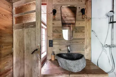 a bathroom with a stone tub in a wooden wall at Tjiftjaf in Retie