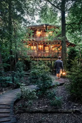 a man walking in front of a wooden house at Buizerd in Retie