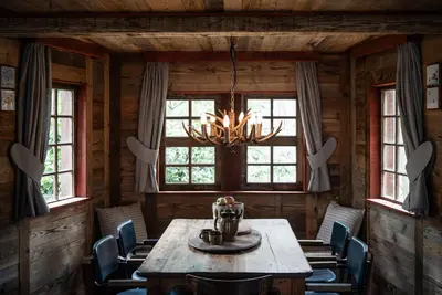 a dining room with a table and chairs and a chandelier at Buizerd in Retie