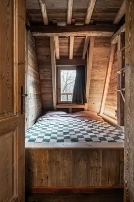 a bed in a wooden room with a window at Buizerd in Retie