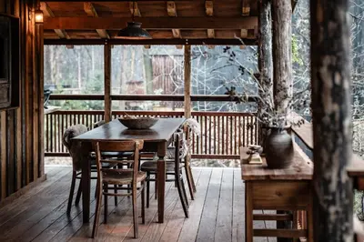 a wooden table and chairs on a wooden deck at Buizerd in Retie
