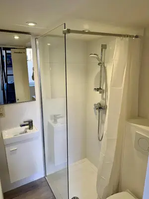 a bathroom with a shower and a toilet and a sink at Studio avec chambre en mezzanine in Brussels