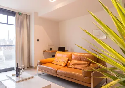 an orange couch in a living room with a window at Guesthouse De Vliere in Beerse