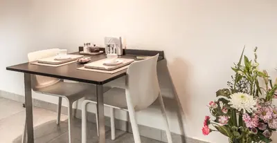 a dining room table with two chairs and flowers at Guesthouse De Vliere in Beerse