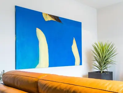 a orange couch in a room with a blue wall at Guesthouse De Vliere in Beerse