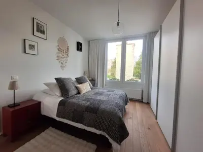 a bedroom with a bed and a window at B&B De Lelie in Schoten