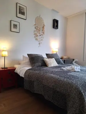 a bedroom with a bed and some pictures on the wall at B&B De Lelie in Schoten