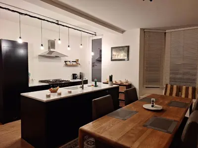 a kitchen and dining room with a wooden table at B&B De Lelie in Schoten