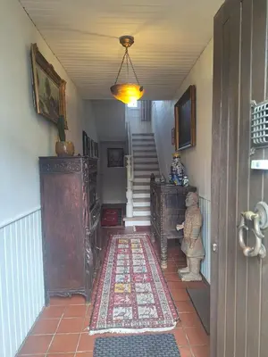 a hallway with a staircase with a rug on the floor at B&B De Lelie in Schoten