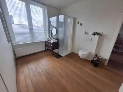 a bathroom with a mirror and a sink and a toilet at B&B De Lelie in Schoten