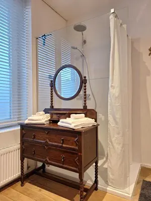 a mirror on top of a dresser in a bathroom at B&B De Lelie in Schoten
