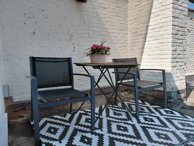 two chairs and a table with a potted plant on it at B&B De Lelie in Schoten