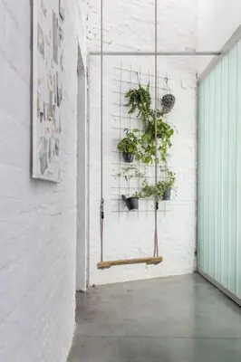 a room with potted plants hanging on a wall at Lightful architectural house in Ghent