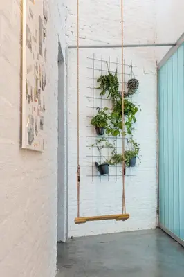 a hanging plant rack with potted plants on a wall at Lightful architectural house in Ghent