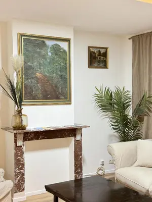 a living room with a table and a painting on the wall at Appartement n4 Bruxelles Centre Ville in Brussels
