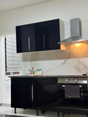 a kitchen with black cabinets and a marble counter top at Appartement n4 Bruxelles Centre Ville in Brussels