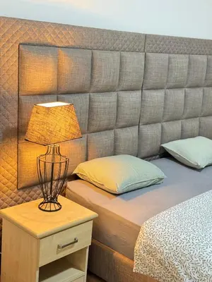 a bed with a headboard and a lamp on a night stand at Appartement n4 Bruxelles Centre Ville in Brussels