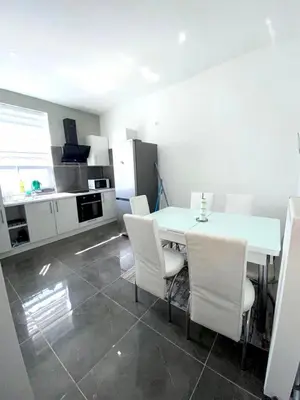 a kitchen with a white table and white chairs at Appartement Bruxelles Belgique in Brussels