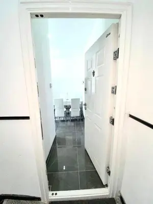 a hallway with a room with a table and white doors at Appartement Bruxelles Belgique in Brussels