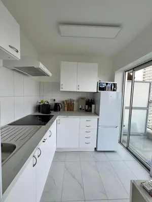 a white kitchen with a sink and a refrigerator at STUDIO Zone touristique in Brussels