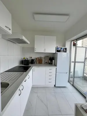 a kitchen with white cabinets and a white refrigerator at STUDIO Zone touristique in Brussels