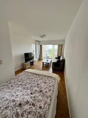 a bedroom with a bed and a living room at STUDIO Zone touristique in Brussels