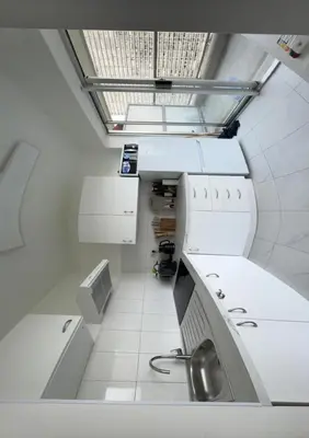 a kitchen with white cabinets and a sink at STUDIO Zone touristique in Brussels