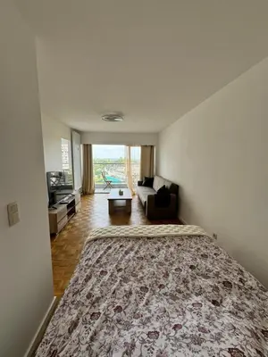 a bedroom with a large bed and a living room at STUDIO Zone touristique in Brussels