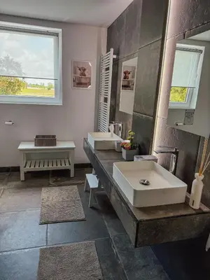 a bathroom with two sinks and a large mirror at Kindvriendelijke vakantiewoning Happy Cow-ter in Belsele