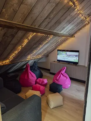a living room with pink chairs and a flat screen tv at Kindvriendelijke vakantiewoning Happy Cow-ter in Belsele