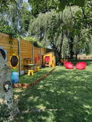 a backyard with a playground with red frisbees on the grass at Kindvriendelijke vakantiewoning Happy Cow-ter in Belsele
