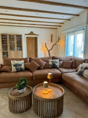 a living room with a brown couch and two tables at Kindvriendelijke vakantiewoning Happy Cow-ter in Belsele
