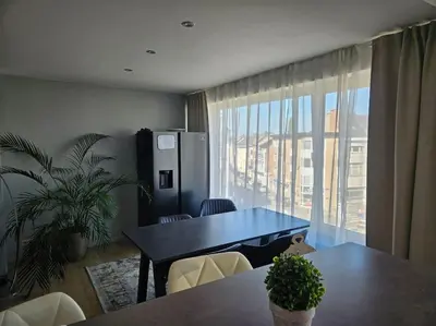 a dining room with a table and a large window at Urban Comfort Mechelen in Mechelen