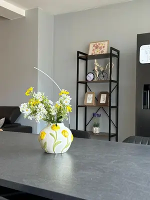 a vase filled with flowers sitting on a table at Urban Comfort Mechelen in Mechelen