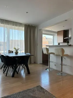 a living room with a table and a piano at Urban Comfort Mechelen in Mechelen
