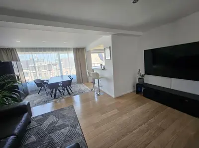 a living room with a table and a large television at Urban Comfort Mechelen in Mechelen