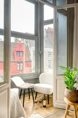 a room with a window with a chair and a table at Ghent's Historic Gem - Your Perfect Hideaway in Ghent