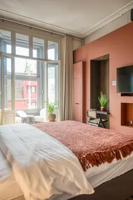 a bedroom with a large bed and a large window at Ghent's Historic Gem - Your Perfect Hideaway in Ghent