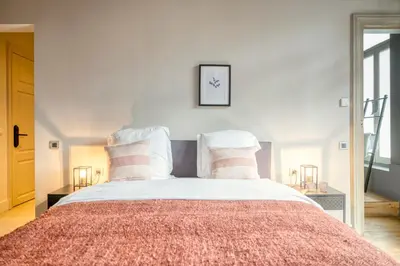 a bedroom with a large bed with pink and white pillows at Ghent's Historic Gem - Your Perfect Hideaway in Ghent