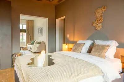 a bedroom with a large bed with a table at Spacious & Luminous Gem in Historic Ghent Building in Ghent