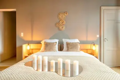 a bedroom with a bed with candles on it at Spacious & Luminous Gem in Historic Ghent Building in Ghent